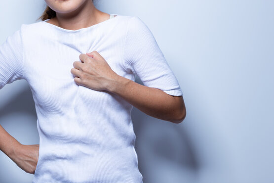 Woman holding her chest due to acute chest pain